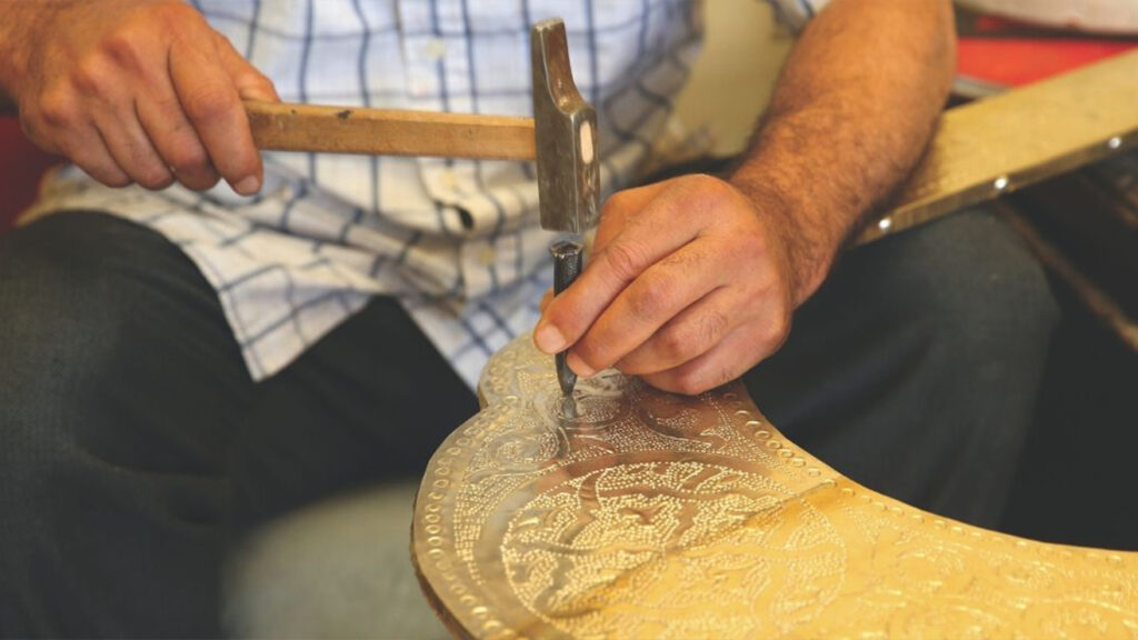 Atelier Fabrication Sculpture avec artisan travaillant une pièce décorative en métal à la main